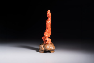 A Chinese carved red coral 'Goddess and Boys' group on a wooden stand, 19/20th C.