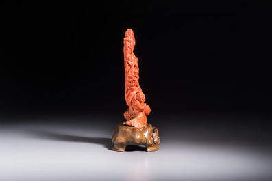 A Chinese carved red coral 'Goddess and Boys' group on a wooden stand, 19/20th C.