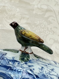 A blue and white Dutch Delft butter tub with a polychrome bird-shaped finial, 18th C.