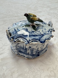 A blue and white Dutch Delft butter tub with a polychrome bird-shaped finial, 18th C.