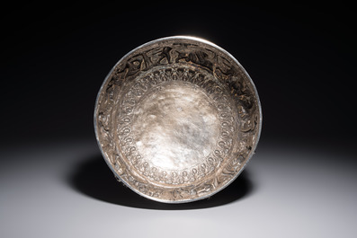 A large repouss&eacute; silver footed bowl depicting a hunting scene, India, late 19/early 20th C.