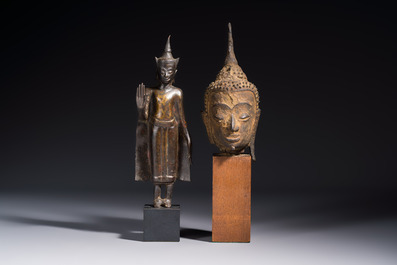 A bronze standing Buddha, a torso of Buddha and four heads of Buddha, Thailand, 17/18th C.