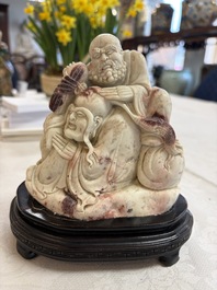 A Chinese carved soapstone 'Luohan' group on a wooden stand, Republic