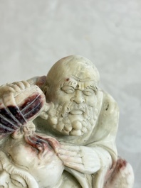 A Chinese carved soapstone 'Luohan' group on a wooden stand, Republic