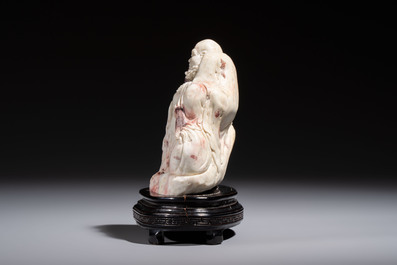 A Chinese carved soapstone 'Luohan' group on a wooden stand, Republic