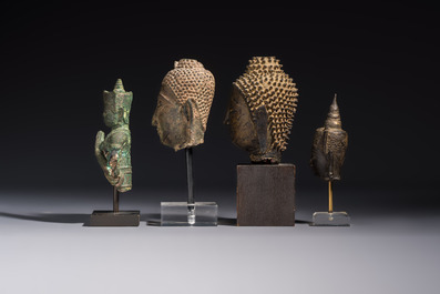 A bronze standing Buddha, a torso of Buddha and four heads of Buddha, Thailand, 17/18th C.