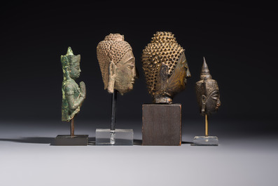 A bronze standing Buddha, a torso of Buddha and four heads of Buddha, Thailand, 17/18th C.