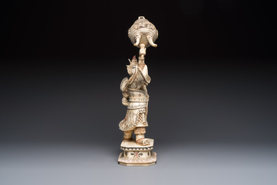 A Chinese polychromed carved bone figure of a warrior raising a tripod censer, 20th C.