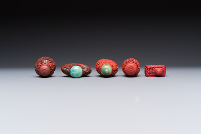 Nine Chinese cinnabar lacquer snuff bottles and a covered box, Qianlong marks, 19/20th C.