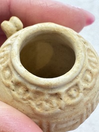 A pair of Chinese bird feeders with moulded design, one unglazed, on later wooden stands, Song