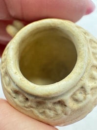 A pair of Chinese bird feeders with moulded design, one unglazed, on later wooden stands, Song