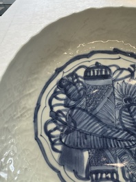 A Chinese blue and white plate with a relief-moulded rim, Wanli