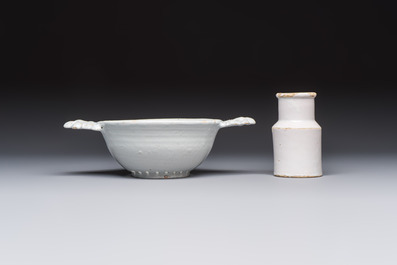 A collection of nine white-glazed Dutch Delft pudding moulds, a mustard pot and a two-handled strainer, 18th C.