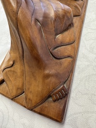 A Balinese carved wooden sculpture of a reclining lady, first half 20th C.