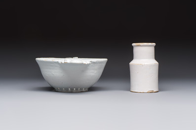 A collection of nine white-glazed Dutch Delft pudding moulds, a mustard pot and a two-handled strainer, 18th C.
