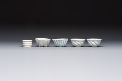 A collection of nine white-glazed Dutch Delft pudding moulds, a mustard pot and a two-handled strainer, 18th C.