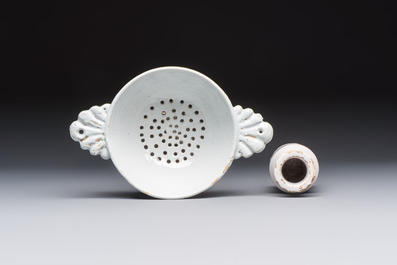 A collection of nine white-glazed Dutch Delft pudding moulds, a mustard pot and a two-handled strainer, 18th C.
