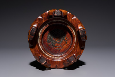A Chinese copper-red-glazed vase on a wooden stand, 20th C.