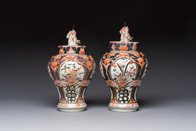 A pair of Japanese Imari baluster vases and covers on wooden stands, Edo, 18th C.