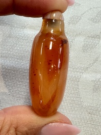 A group of four Chinese porcelain and agate snuff bottles, a miniature vase and a carved seed, Yongzheng and Qianlong marks, 19/20th C.