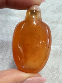 A group of four Chinese porcelain and agate snuff bottles, a miniature vase and a carved seed, Yongzheng and Qianlong marks, 19/20th C.