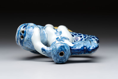 A blue and white Dutch Delft ewer in the shape of a putto on a dolphin on a wavy green ground, 18th C.