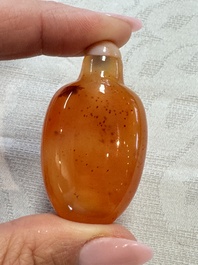 A group of four Chinese porcelain and agate snuff bottles, a miniature vase and a carved seed, Yongzheng and Qianlong marks, 19/20th C.