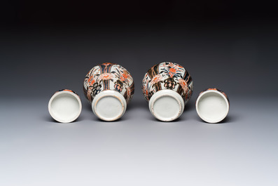 A pair of Japanese Imari baluster vases and covers on wooden stands, Edo, 18th C.