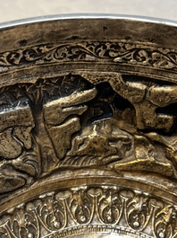 A large repouss&eacute; silver footed bowl depicting a hunting scene, India, late 19/early 20th C.