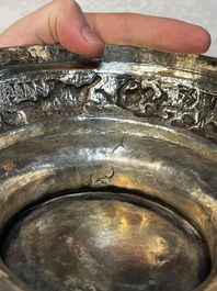 A large repouss&eacute; silver footed bowl depicting a hunting scene, India, late 19/early 20th C.