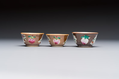A Chinese famille verte teapot and three famille rose capucine-ground cups and saucers, Kangxi/Qianlong