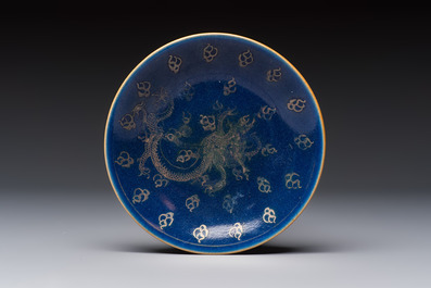 Four Chinese famille rose saucers and a gilt-decorated powder-blue-ground saucer, Qianlong and Jiaqing marks, 18/19th C.