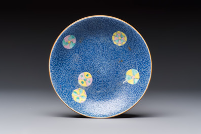 Four Chinese famille rose saucers and a gilt-decorated powder-blue-ground saucer, Qianlong and Jiaqing marks, 18/19th C.