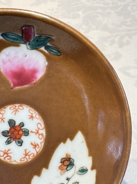 A Chinese famille verte teapot and three famille rose capucine-ground cups and saucers, Kangxi/Qianlong