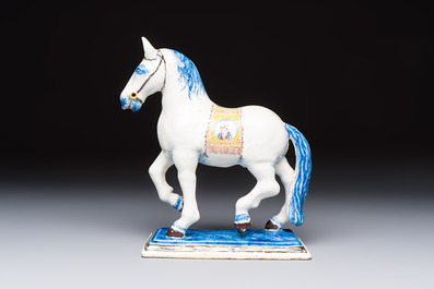 A polychrome Dutch Delft model of a standing horse with a figurative saddle cloth, 18th C.