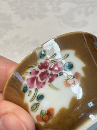 A Chinese famille verte teapot and three famille rose capucine-ground cups and saucers, Kangxi/Qianlong