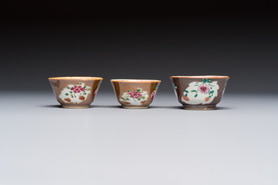 A Chinese famille verte teapot and three famille rose capucine-ground cups and saucers, Kangxi/Qianlong