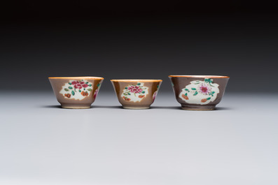 A Chinese famille verte teapot and three famille rose capucine-ground cups and saucers, Kangxi/Qianlong