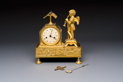 A French fire-gilt mantel clock with a music making cherub, early 19th C.