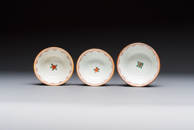 A Chinese famille verte teapot and three famille rose capucine-ground cups and saucers, Kangxi/Qianlong