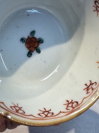 A Chinese famille verte teapot and three famille rose capucine-ground cups and saucers, Kangxi/Qianlong