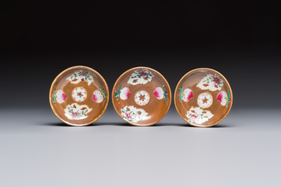 A Chinese famille verte teapot and three famille rose capucine-ground cups and saucers, Kangxi/Qianlong