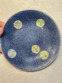 Four Chinese famille rose saucers and a gilt-decorated powder-blue-ground saucer, Qianlong and Jiaqing marks, 18/19th C.