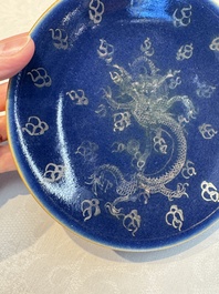 Four Chinese famille rose saucers and a gilt-decorated powder-blue-ground saucer, Qianlong and Jiaqing marks, 18/19th C.