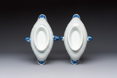 A pair of Chinese blue and white handled sauce boats and stands with pagodas along a river, Qianlong