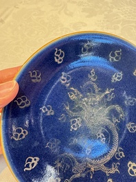 Four Chinese famille rose saucers and a gilt-decorated powder-blue-ground saucer, Qianlong and Jiaqing marks, 18/19th C.