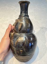 Three khmer-style brown-glazed anthropomorphic gourd-form bottles, probably 12/13th C.