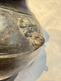A miniature Chinese archaic bronze wine vessel with Taotie handles, 'Hu 壺', Han