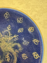 Four Chinese famille rose saucers and a gilt-decorated powder-blue-ground saucer, Qianlong and Jiaqing marks, 18/19th C.