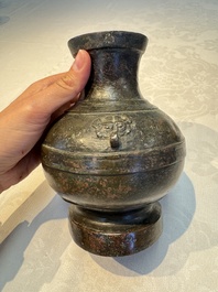 A miniature Chinese archaic bronze wine vessel with Taotie handles, 'Hu 壺', Han
